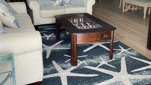 A living room with a sofa, coffee table, and patterned rug. - Dog Days of Summer on the Beach! August/Fall Dates Open
Cyndi 386-361-5882 (Daytona Beach Shores)