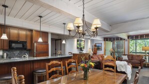 A spacious kitchen with wooden cabinets, a central island, and pendant lighting. - Top of the Village~Ski-in/out~HT~Pool~Grill~Parking (Snowmass Village)