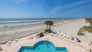Ein Poolbereich mit Blick auf Strand und Meer.