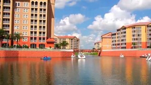 Un hotel frente al río con varias edificaciones, un río tranquilo y barcos.