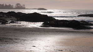 A beach with rocky outcrops and calm waves.