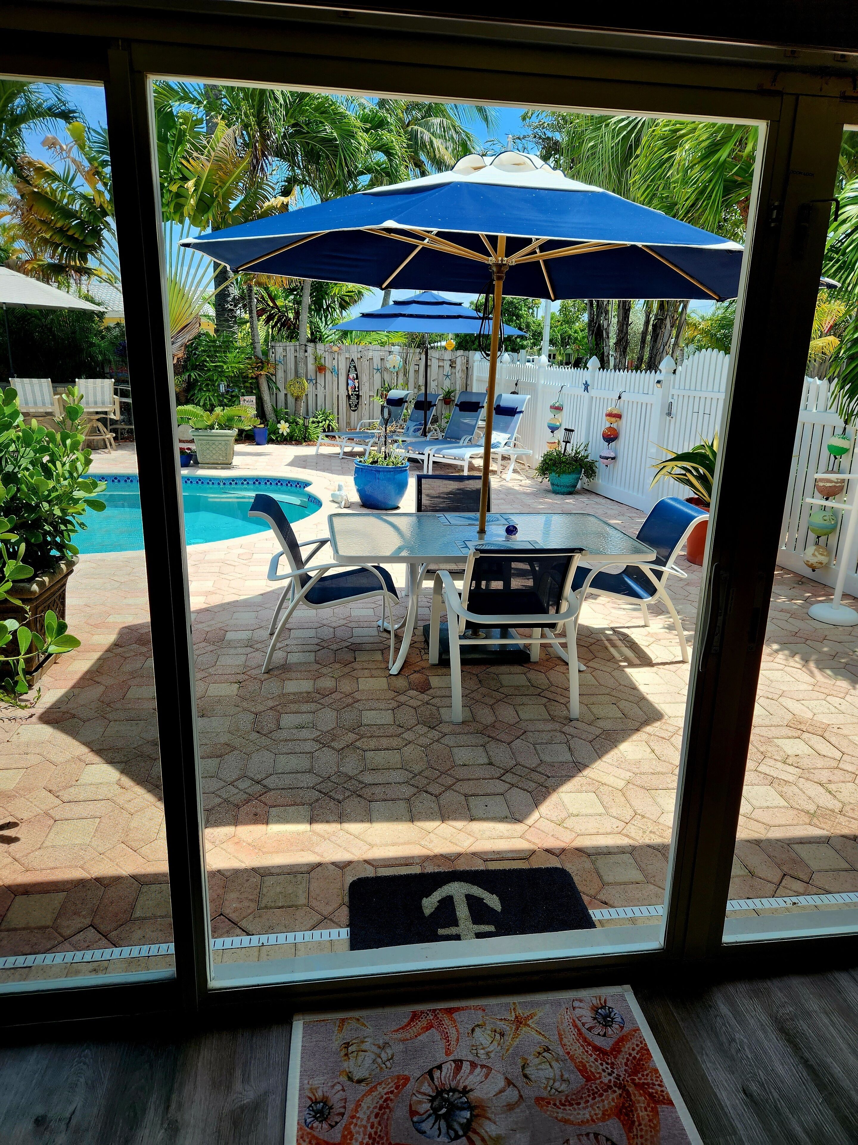 Un espace extérieur aménagé avec une piscine, des chaises longues et des parasols.