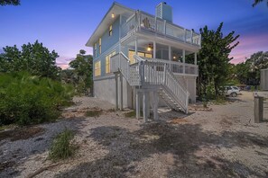 A two-story house with a balcony and a staircase leading to the upper level.