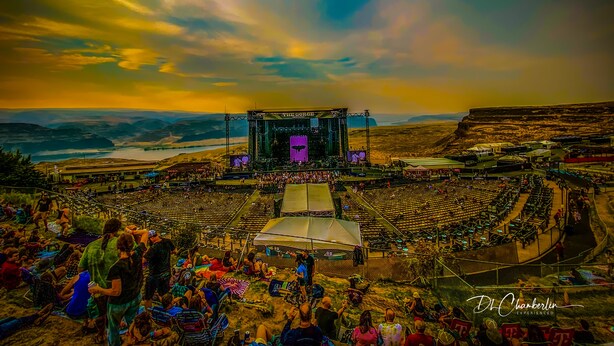 A large outdoor amphitheater with tiered seating and a stage, surrounded by hills and a body of water. - Rent Like a Rock Star @ Hotel Rock in Crescent Bar - Sunserra! (Quincy)