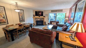 Living room w/ gas fireplace, sofa bed, and balcony w/ propane BBQ grill