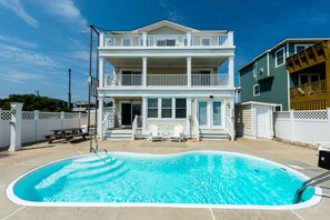 A two-story house with a swimming pool, a picnic table, and two Adirondack chairs. -  Make Memories at Barefoot Daze (Kitty Hawk)