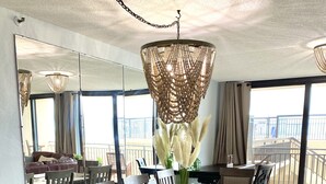 A spacious dining area with a long wooden table, multiple chairs, and a large mirror.