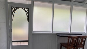 A room with a white door, frosted windows, a wooden bench, and a wooden chair. - Relax at the Island Escape in Downtown Melbourne, minutes from beautiful beaches (Melbourne)