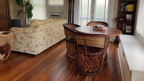 A cozy living room with a sofa, a dining table with chairs, a lamp, and a bookshelf. - Relax at the Island Escape in Downtown Melbourne, minutes from beautiful beaches (Melbourne)