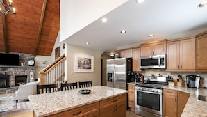 A kitchen with granite countertops, wooden cabinets, a stainless steel refrigerator, a microwave, a stove, and a built-in oven. - “Mountain Escape-7BR, Game Room, Fire Pit Close to Skiing and Trails!” (Lake Harmony)