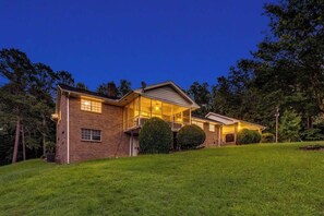 A two-story house with a balcony, a garage, and a well-maintained lawn.