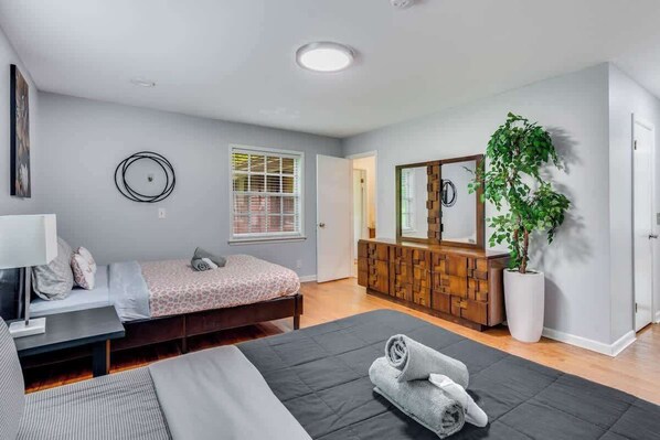 A modern bedroom with a bed, bedside table, and a large mirror.