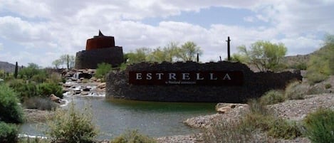 Un panneau indiquant « ESTRELLA » dans un paysage dĂ©sertique, avec un petit cours dâeau et une vĂ©gĂ©tation clairsemĂ©e.