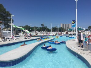 A swimming pool with multiple lanes and people using inflatable rings. - Beautiful Ocean Lakes Beach Home......100 Yards to the Beach. (Myrtle Beach)