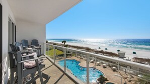 A balcony with a pool, beach view, and outdoor seating. - 310 Sterling Sands Wake Up to Ocean Views in This Luxurious Beachfront Oasis! (Destin)