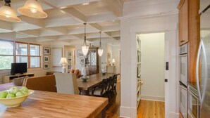 Una cocina amplia con suelo de madera, un comedor con mesa de madera y un refrigerador moderno.
