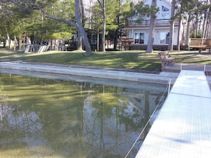 Relax by the serene pool surrounded by lush greenery and comfortable benches.