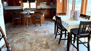 A spacious kitchen with a central island, wooden cabinets, and a dining area with a table and chairs. - Spectacular views and rural life, yet close to Boise (Boise)