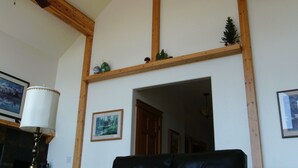 A room with a wooden ceiling, a ceiling fan, a black leather sofa, a small Christmas tree, and framed pictures on the walls. - Spectacular views and rural life, yet close to Boise (Boise)