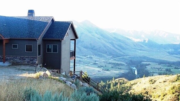 A house with a stone foundation, a sloped roof, and a wooden deck. - Spectacular views and rural life, yet close to Boise (Boise)