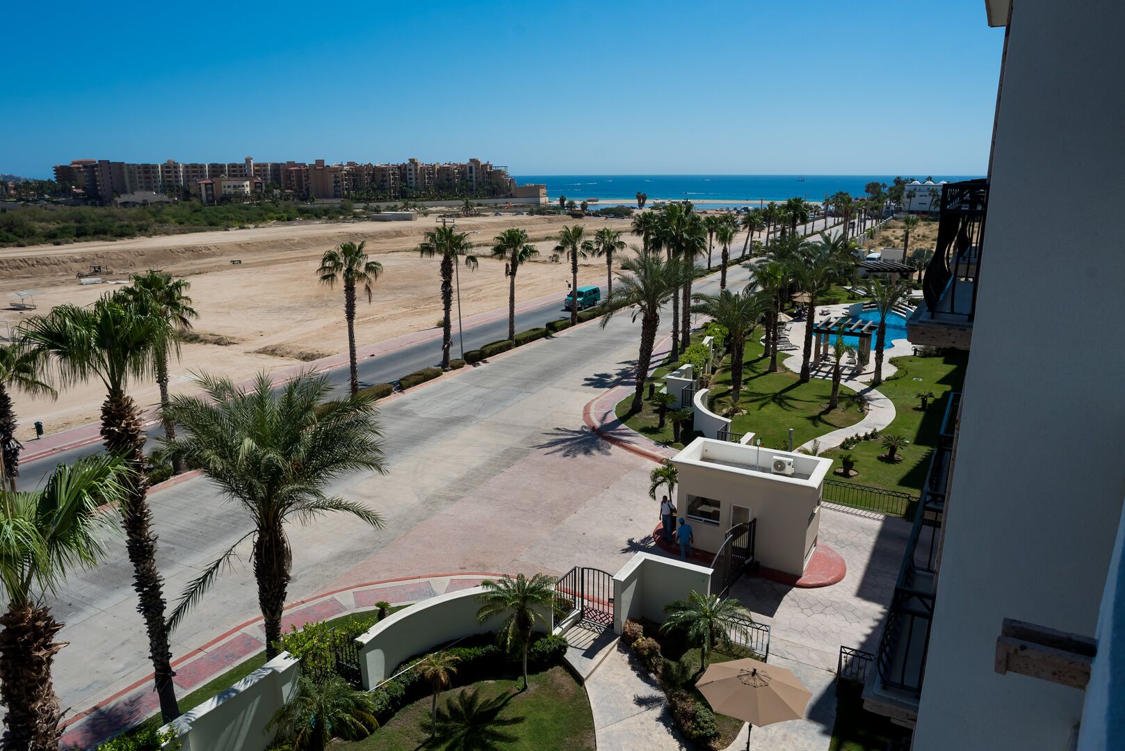 Ein Resort mit Pool, Palmen und Blick auf Strand und Meer.