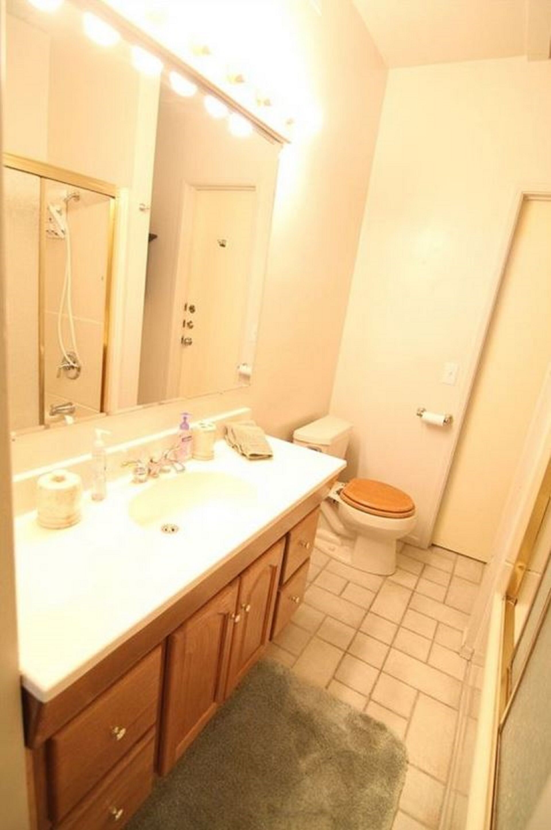 Un baño con lavamanos, espejo, inodoro y ducha.