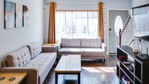 A modern living room with a sofa, a coffee table, and a TV stand.