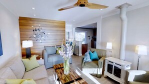 Una sala de estar moderna con sofá, sillones, una mesa de centro y chimenea.