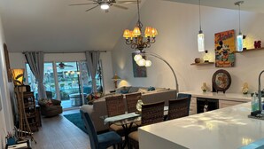 A modern living room with a dining area, a ceiling fan, and a view to the outside. - BEST in Monterey Country Club-South-New Remodel-2024-STR or monthly-185 Gran Via (Palm Desert)