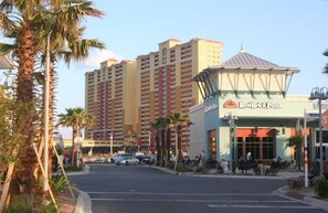 A Red Brick Pizza restaurant with a classic American design, located in a busy urban area with tall buildings and palm trees.