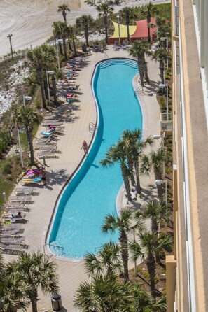 A pool area with lounge chairs and palm trees.