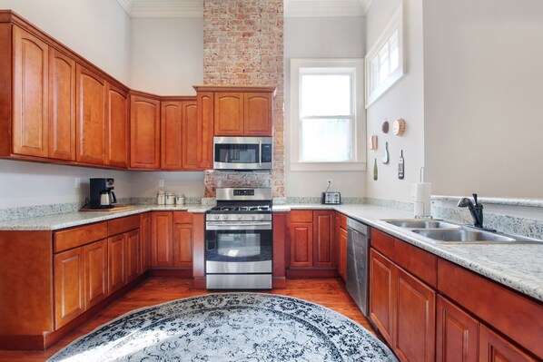 A kitchen with wooden cabinets, a stainless steel oven, a microwave, and a granite countertop. - Upscale and Historic, 2 blocks to Streetcar, 4 to French Quarter, 6 to Frenchmen (New Orleans)