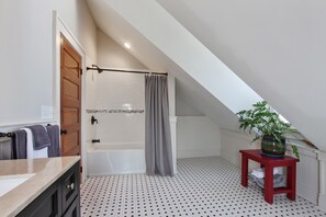 A modern bathroom with a bathtub, shower, and a small red table with a plant. - Upscale and Historic, 2 blocks to Streetcar, 4 to French Quarter, 6 to Frenchmen (New Orleans)