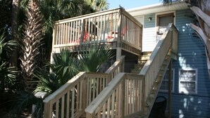 Une terrasse en bois à deux niveaux, avec un escalier menant à un balcon.