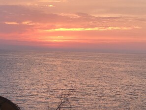 Un atardecer sobre un mar tranquilo con un horizonte despejado.