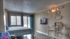 Un dormitorio con cama, televisor, escritorio y silla.