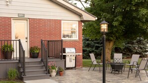A brick house with a grill and outdoor seating. - Kingsway Guesthouse. Come, relax, and enjoy your time in Amish country! (Millersburg)