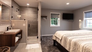 A modern bathroom with a shower, vanity, and a large mirror. - Kingsway Guesthouse. Come, relax, and enjoy your time in Amish country! (Millersburg)
