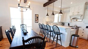 A spacious kitchen with white cabinets, a wooden dining table, and multiple chairs. - *PRIVATE BEACH*    *PRIVATE POOL*    *ELEVATOR*    *6 BEACH BIKES* (Panama City)