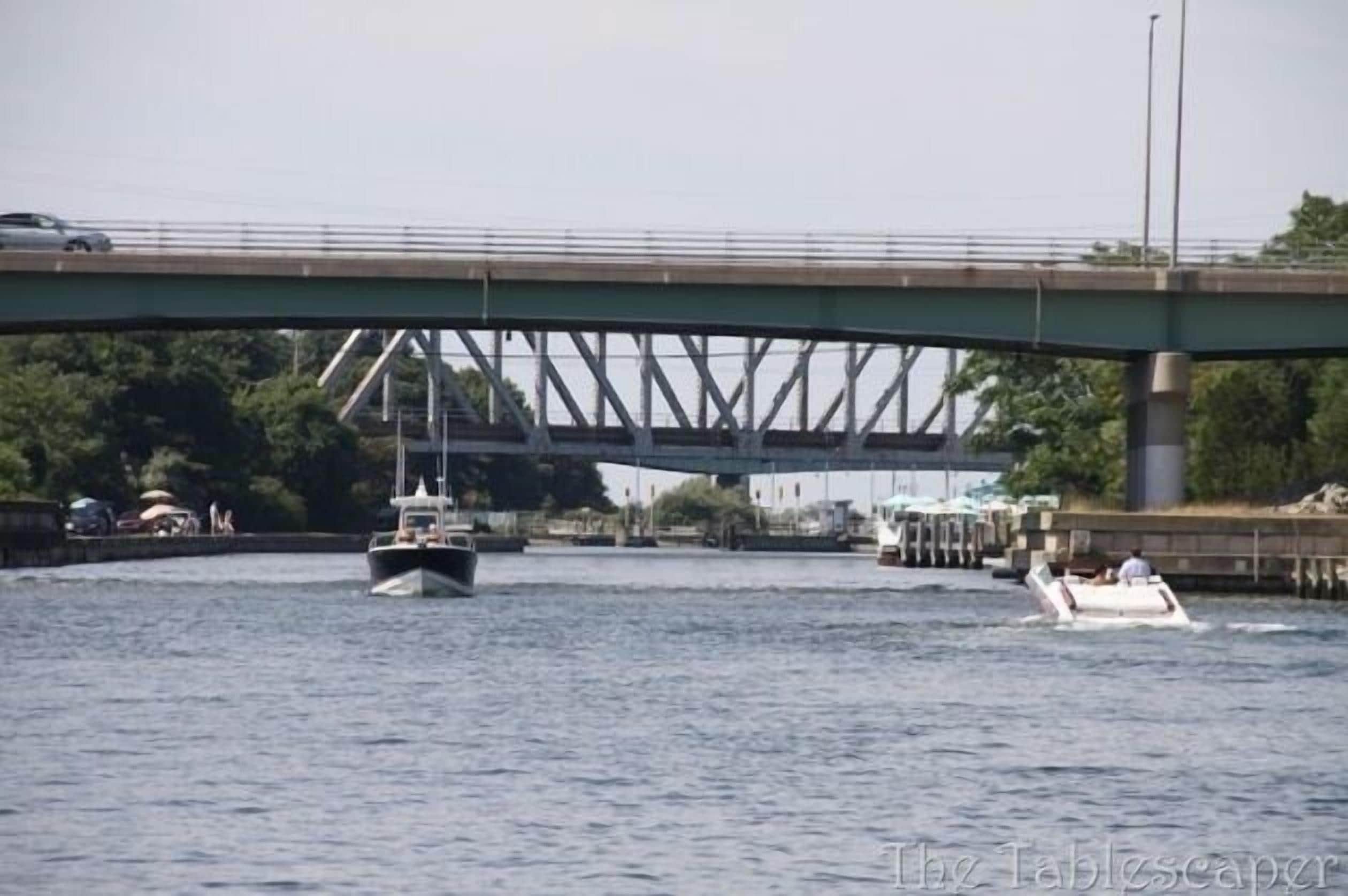 A river with boats, a bridge, and a dock.