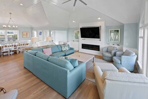 A spacious living room with a large sectional sofa, a fireplace, and a television.