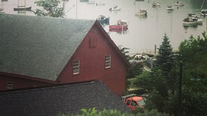 Un port brumeux avec des bateaux, un bâtiment rouge et un camion.
