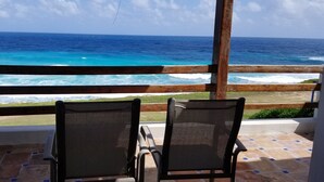 A balcony with two chairs facing a view of the ocean. - Beautiful Oceanfront Mexican Villa with Infinity Pool, and Spectacular View (Isla Mujeres)