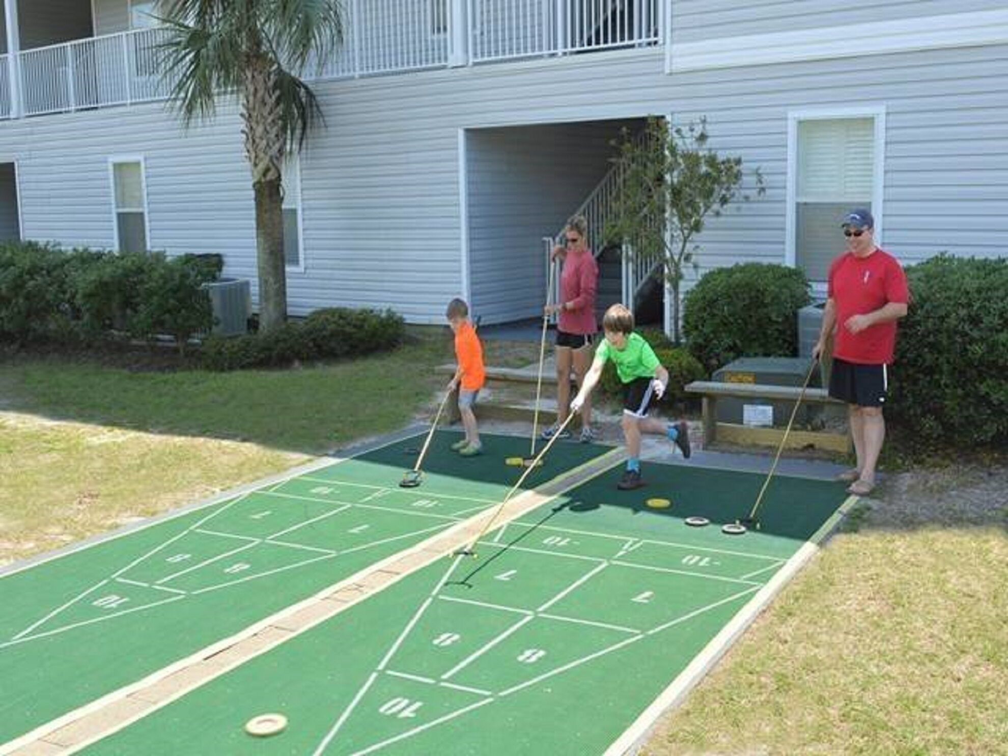 Ein Shuffleboard-Spielfeld mit Spielern und Zuschauern.