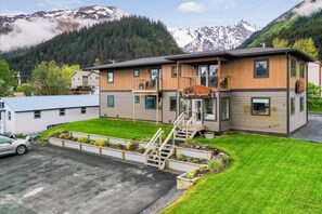 En toetages bygning med facade af træ, en balkon og en trappe op til øvre etage.