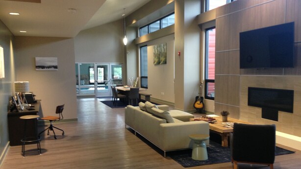 A spacious living area with a large sofa, a coffee table, and a fireplace. There is a dining area in the background with a table and chairs. - A cozy non-smoking condo on the Fraser River in downtown Winter Park. (Winter Park)