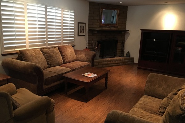 Living room with wood burning fireplace and cable TV.