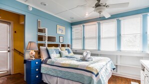 A bedroom with a bed, a dresser, a lamp, and a ceiling fan. - 'Roger's Lighthouse' in the Heart of Seaside. Bikes included.  (seaside)