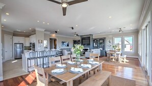 A spacious kitchen with modern appliances, a dining area with a wooden table set for six, and a large island with bar stools. - Ask for Discounts!! Palm Manor by Exclusive Properties  Pool, Elevator, Views (Isle of Palms)