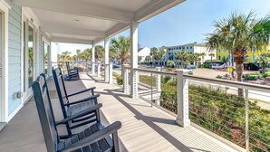 A covered outdoor area with benches, a railing, and a view of buildings and palm trees. - Ask for Discounts!! Palm Manor by Exclusive Properties  Pool, Elevator, Views (Isle of Palms)